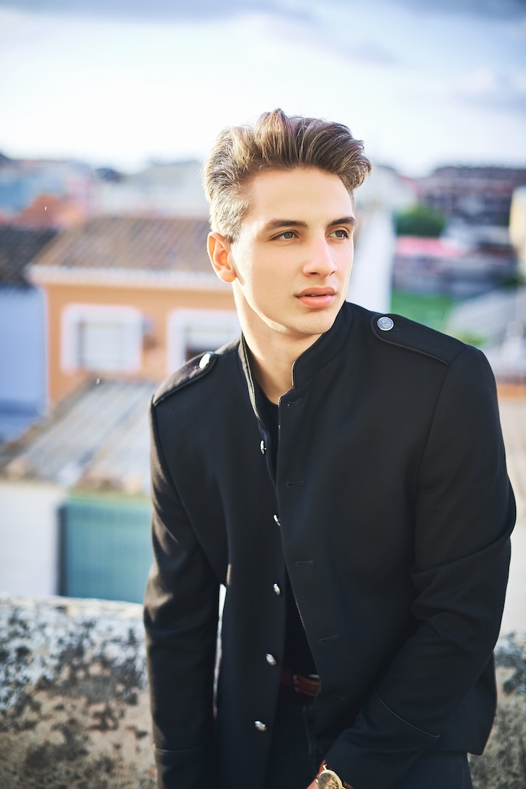 Photo portrait of handsome young man in black posing on the street