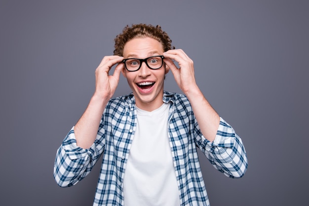 Portrait of handsome young man in casual checkered shirt touching glasses