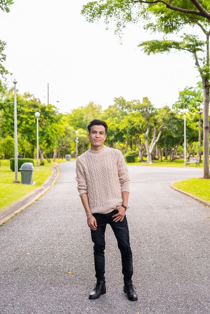 Portrait of handsome young man in park during summer