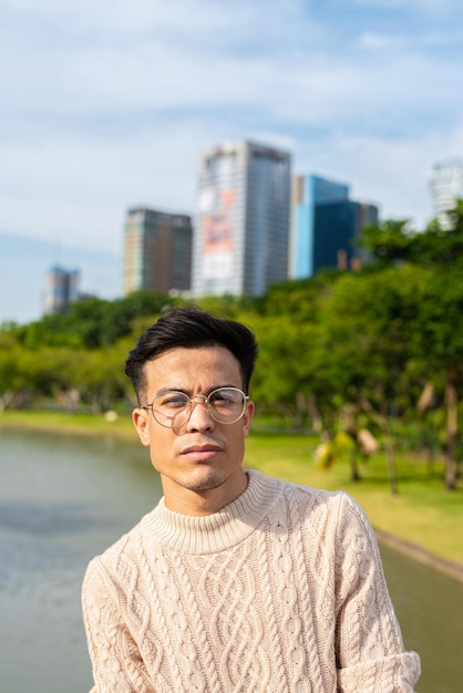 Portrait of handsome young man in park during summer