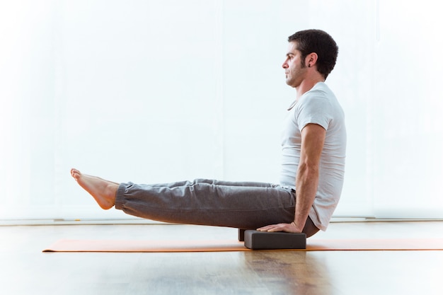 Portrait of handsome young man practicing acro yoga at home