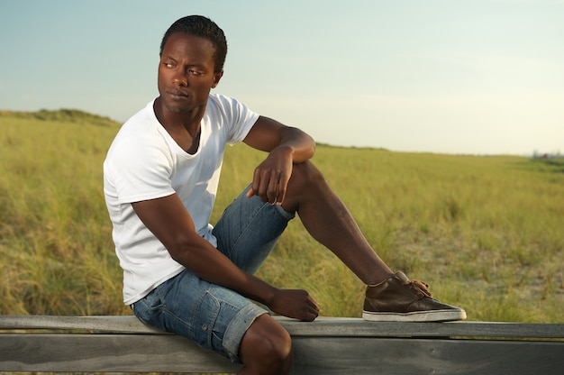 Portrait of a handsome young man sitting alone outside