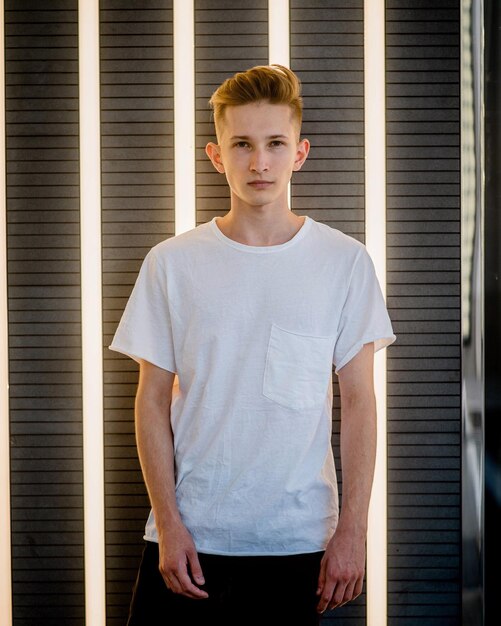 Photo portrait of handsome young man standing against illuminated light