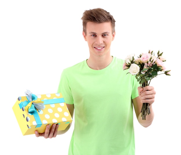 Portrait of handsome young man with flowers and gift, isolated on white