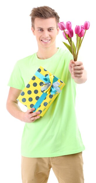 Portrait of handsome young man with flowers and gift, isolated on white