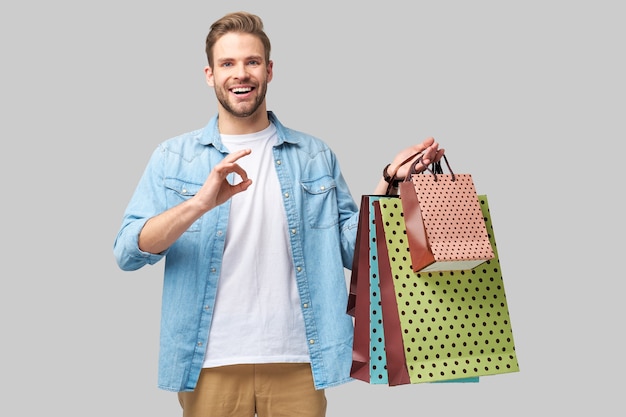 Portrait of a handsome young man with shopping bags.