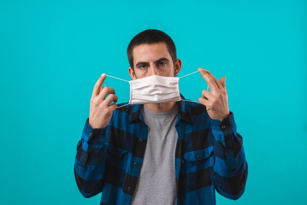 Portrait of handsome young man with surgical medical mask looking at camera