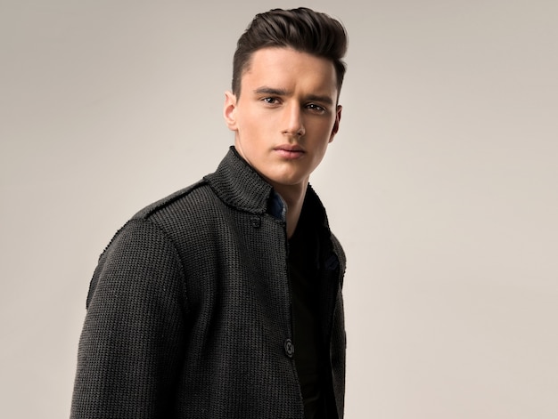 Portrait of a handsome young man with trendy hairstyle, dressed in a stylish and fashionable wool jacket.Man attractiveness and hairdressing art.