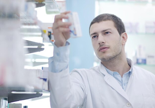 Foto ritratto di un bel giovane farmacista chimico in piedi in farmacia farmacia