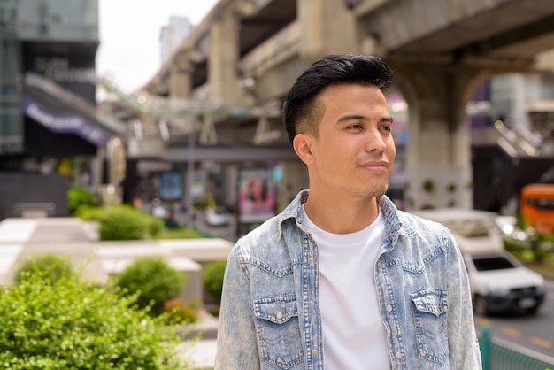 Portrait of handsome young stylish man outdoors in city