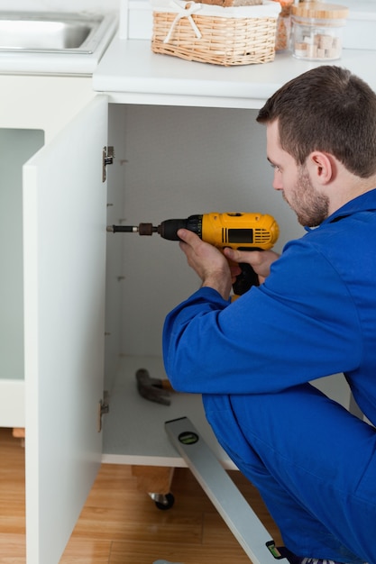 Portrait of a handyman fixing a door