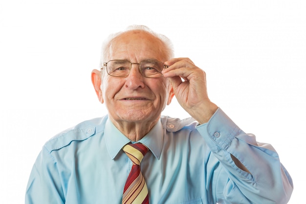 Portrait of happy 90 year old senior man holding glasses, smiling and looking at camera isolated on white background.