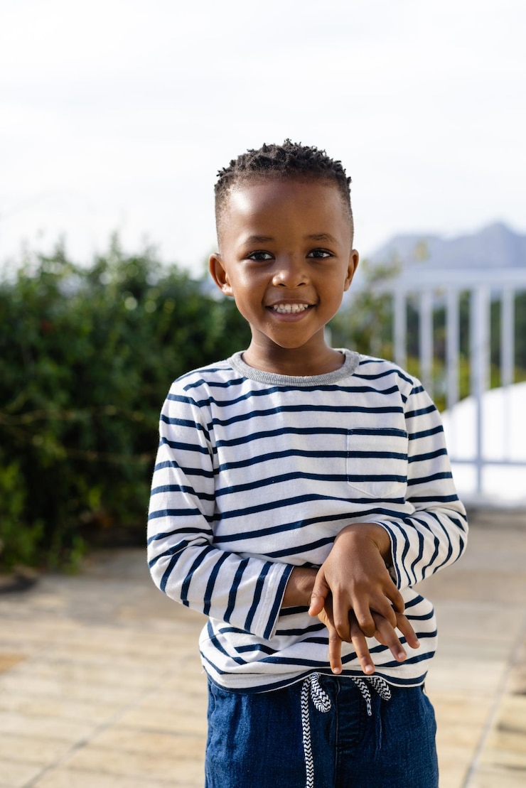 Photo portrait of happy african american boy staying on sunny terrace. lifestyle, nature, childhood and domestic life, unaltered.