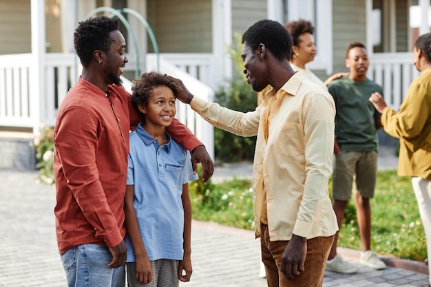 夏の屋外パーティーや会議中に屋外でおしゃべりをするアフリカ系アメリカ人の幸せな家族のポートレート