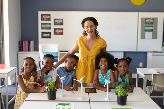 Photo portrait of happy african american students with caucasian young female teacher with windmill models
