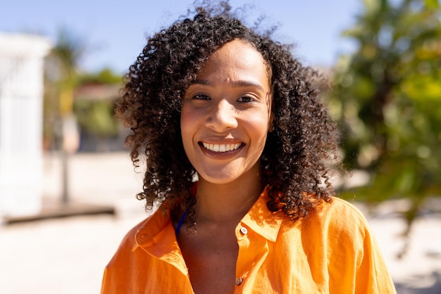 Portrait of happy african american woman looking at camera and smiling at beach. Spending quality time, lifestyle, summertime and vacation concept.