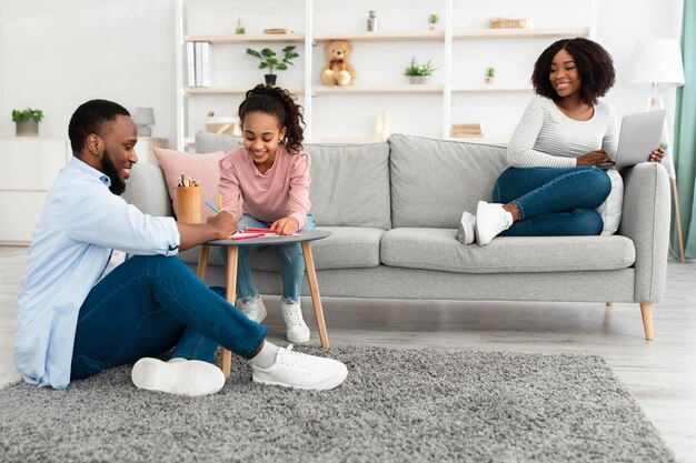 Portrait of happy afro family spending time at home together