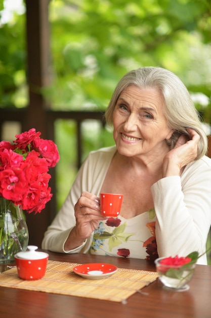 Portrait of a happy aged woman drinking coffee