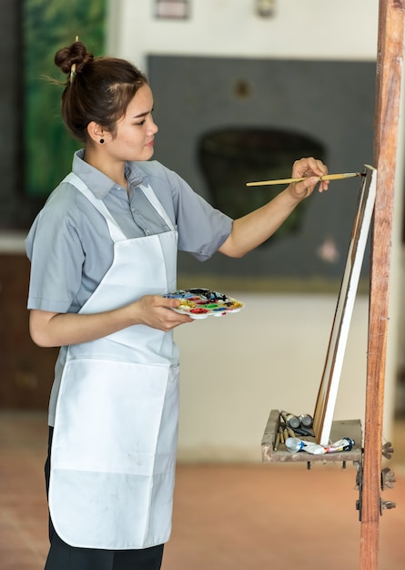 Photo portrait of a happy artist with a palette in hands on the foreground