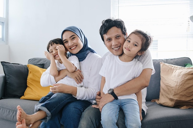 Photo portrait of happy asian family at home smiling parents with kids at home