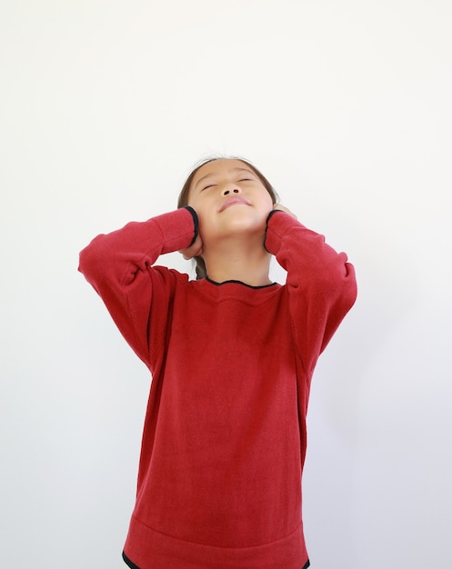 Portrait of happy Asian little child placing hands on ears. Joyful kid closed eyes and smiling on white isolated background