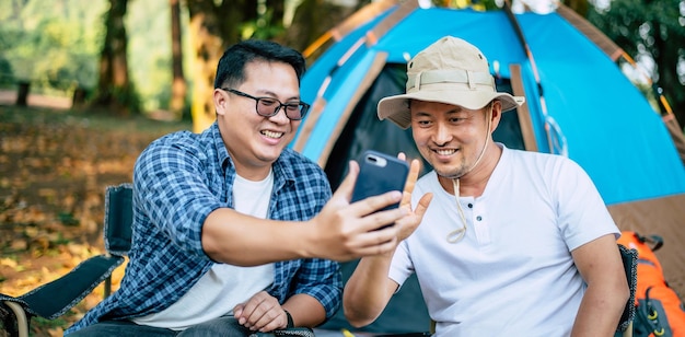 Portrait happy Asian man friends Making a video call with smartphone in camping