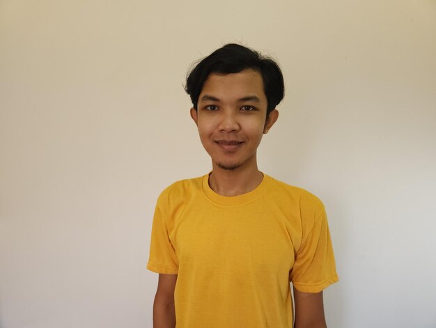 Portrait of happy Asian man in yellow shirt on isolated white background