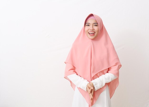 A portrait of happy asian muslim woman wearing a veil or hijab\
smiling and looking at camera. isolated on white background with\
copy space