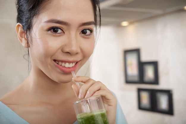 스무디를 마시는 행복 한 아시아 여자의 초상화