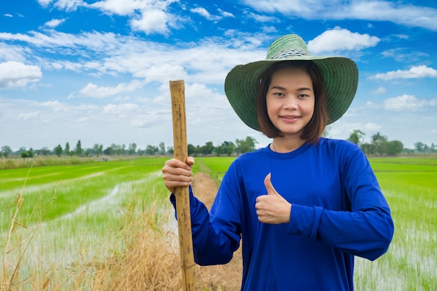 Portrait happy asian woman is smiling. farmer thumb up standing  at rice field