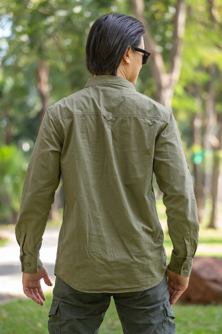 Portrait of happy asian young man in long sleeve shirt and green pant standing  in the park