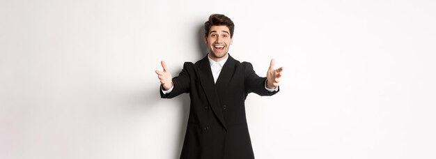 Photo portrait of happy attractive man in suit hosting a party reaching hands forward to greet you want to