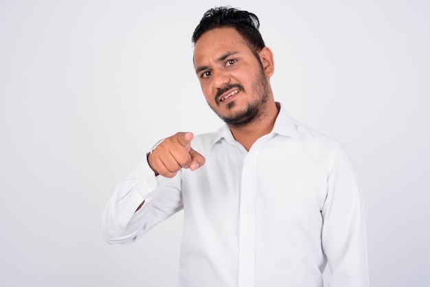 portrait of happy bearded Indian businessman pointing at front