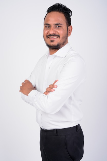 portrait of happy bearded Indian businessman smiling with arms crossed