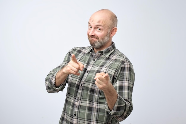 Portrait of happy bearded man pointing at you making a choice