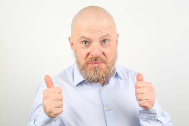 Portrait of a happy bearded man in a shirt with arms raised