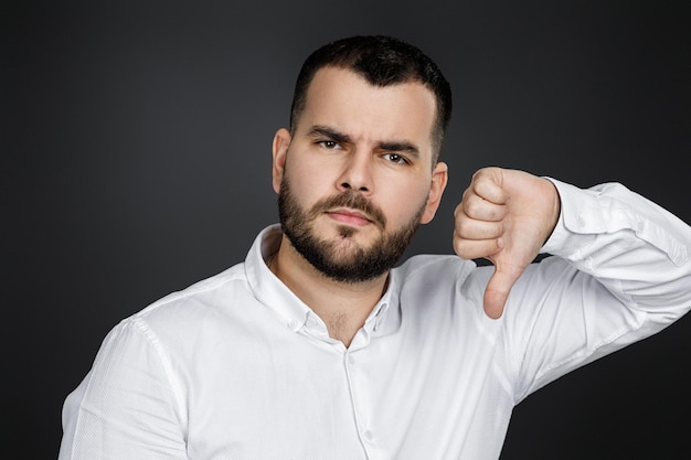 Portrait of happy bearded man showing thumbs down