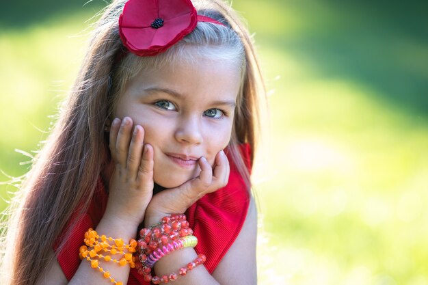 Portrait of happy beautiful child girl outdoors enjoying warm sunny summer day.