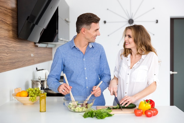 Ritratto di una bella coppia felice che cucina insieme in cucina