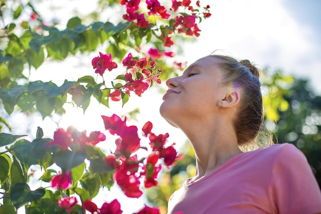 Portrait of happy beautiful girl young positive woman is smelling beautiful yellow flowers in the