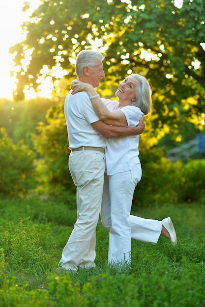 Portrait of happy beautiful senior couple dancing in summer park