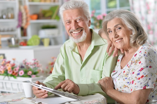 Portrait of happy beautiful senior couple using tablet  at home