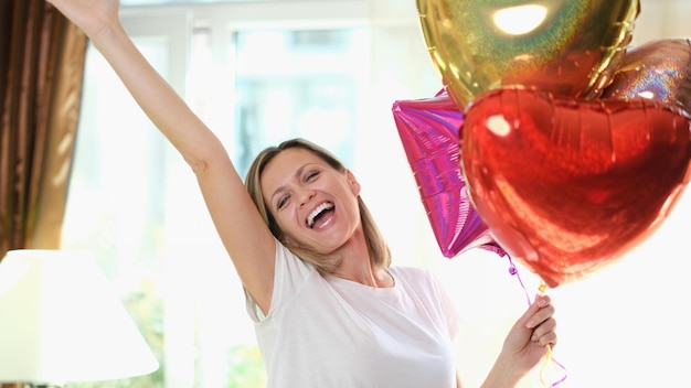 Portrait of happy beautiful woman with heart shaped air balloons st valentines day happy