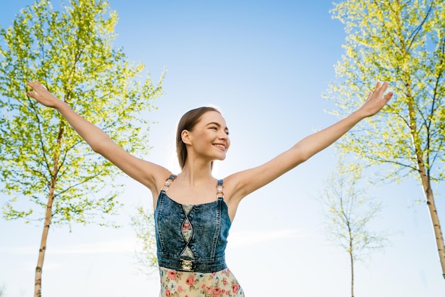 Portrait happy beautiful young woman relaxing in park in long dress Joyful