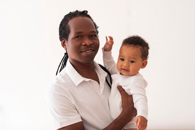 손에 귀여운 작은 아기와 함께 행복 한 흑인 아버지의 초상화