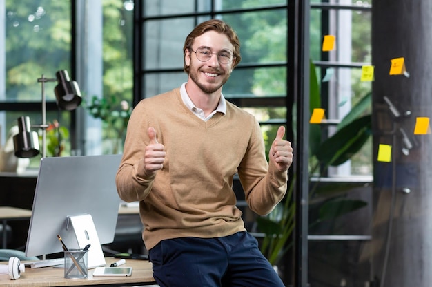 Portrait of happy blond man inside office man in casual clothes smiling and looking at camera young