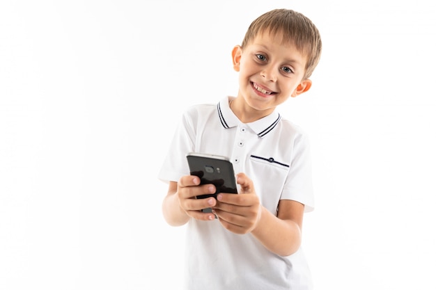 Portrait of happy boy chatting with his friends or playing phone games and smiles