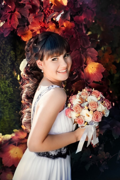 Portrait of the happy bride in autumn park