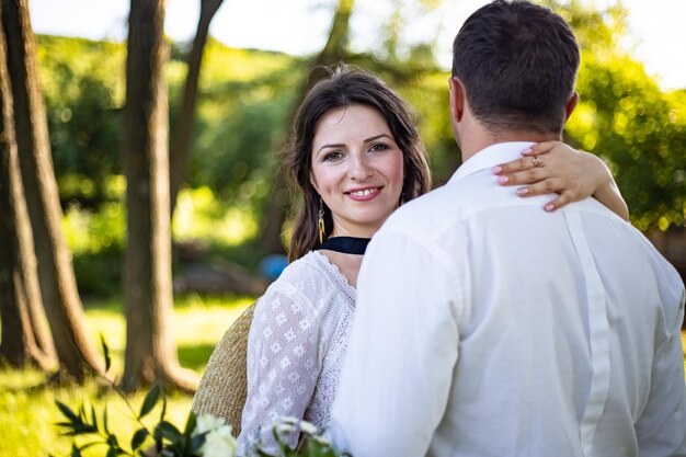 Portrait of a happy bride and groom in boho style wedding dresses against the backdrop of beautiful nature