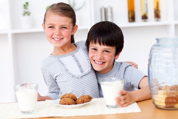 Portrait of  happy brother and sister eating biscuits 